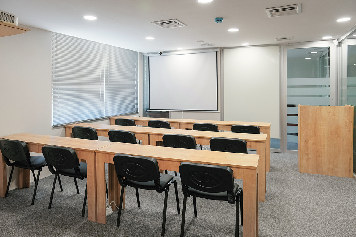 Düzenli masalarla kurulmuş seminer alanı